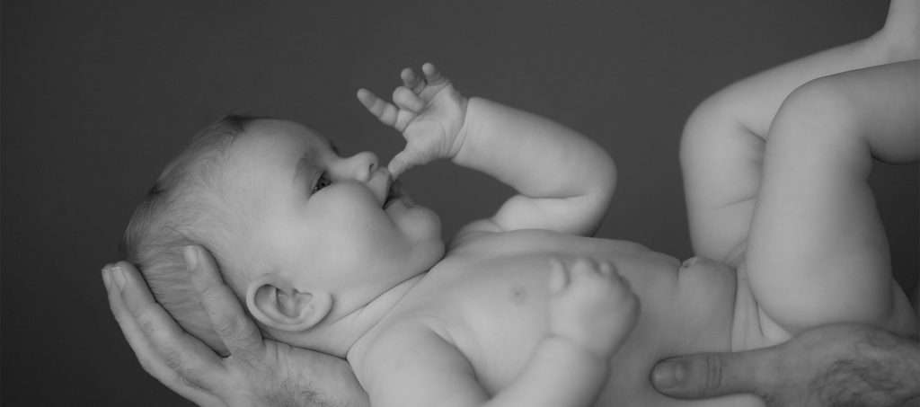 Neugeborenen Fotoshooting | Neugeborenes Baby liegt auf dem Arm