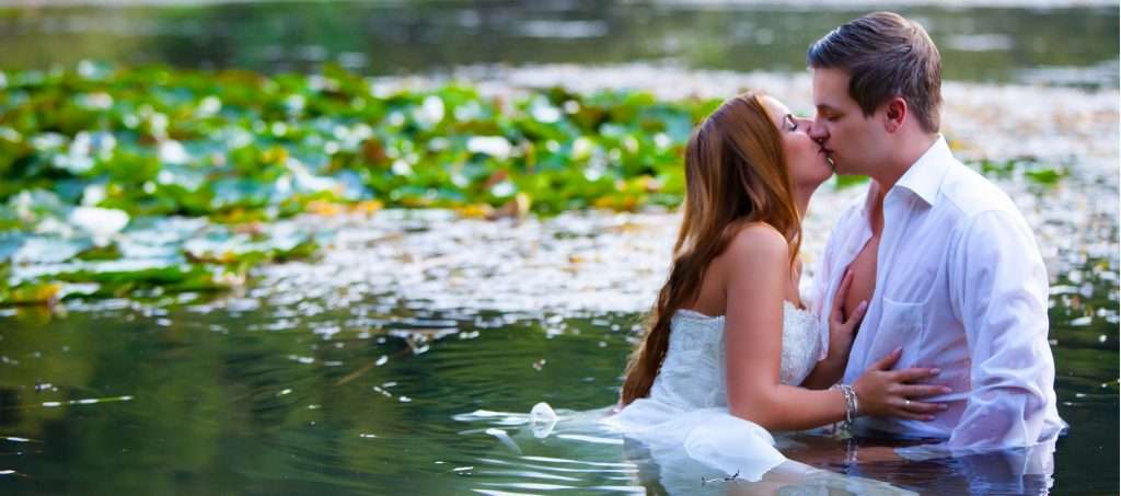 Trash the Dress Fotoshooting | Hochzeitspaar küssend im See