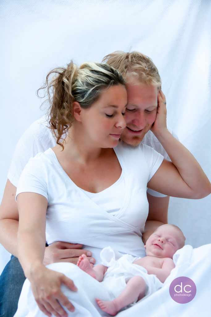 Neugeborenes Fotoshooting mit einem jungen Elternpaar mit lächelndem Baby