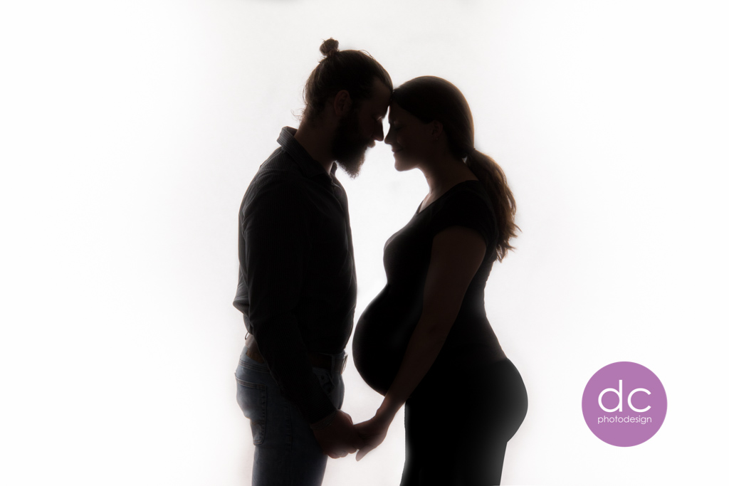 Eine bezaubernde Schwangerschaftsaufnahme, die ein glückliches Pärchen zeigt, im Fotostudio Hanau.