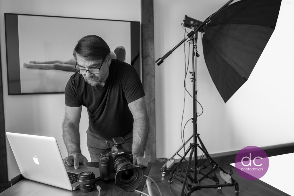 Akt Fotograf Roger De Castro bei der Überprüfung der Akt Aufnahmen im Fotostudio 