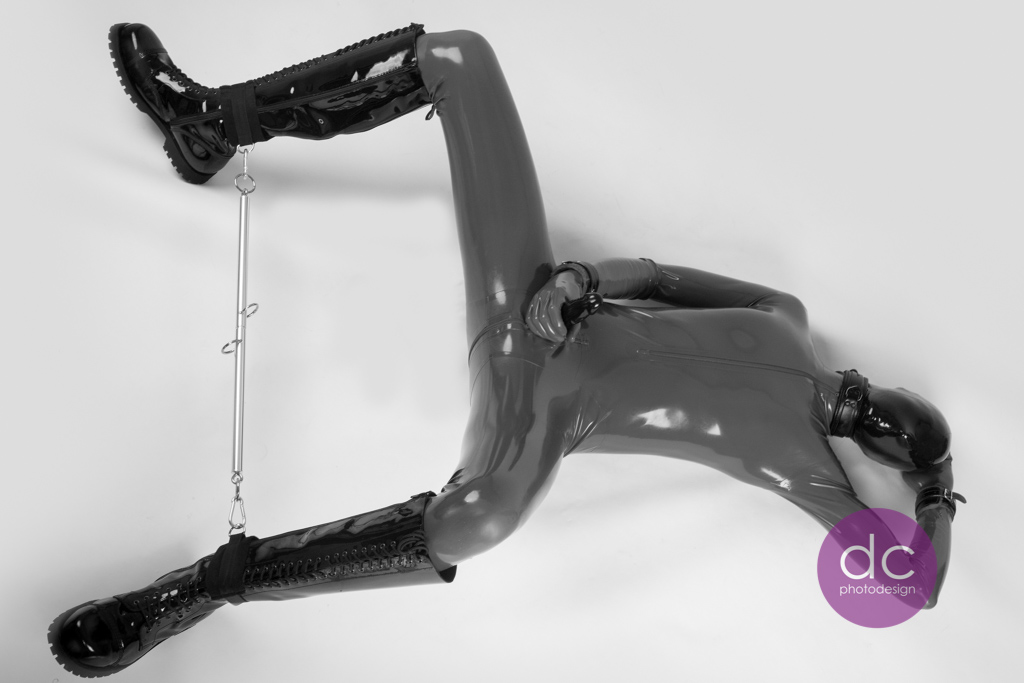 Latex fotografie | Mann in rotem Latexoutfit liegend