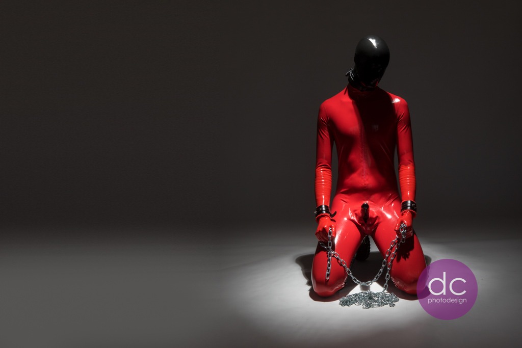 Penis aus schwarzen Latex und Mann mit roten Latex Catsuit - Latex Fotoshooting im Fotostudio Hanau - dc photodesign